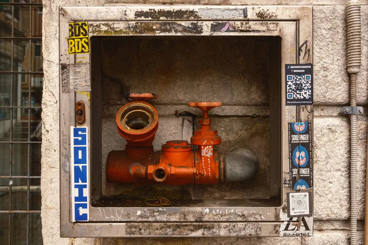 A water valve stained rust orange inside its metal frame